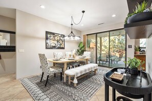 Formal dining area with seating for six, opening onto a covered paver patio.