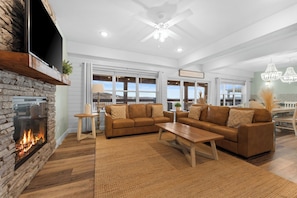 - Inviting living room featuring plush leather sofas and a stunning stone fireplace
- Large windows flood the space with natural light and frame picturesque lake views
- Perfect for family game nights, movie marathons, or sipping wine by the fire