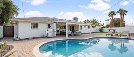 Private Backyard featuring a sparkling pool, Grill, private patio with a smart TV and outdoor seating, sun loungers, and mini golf.