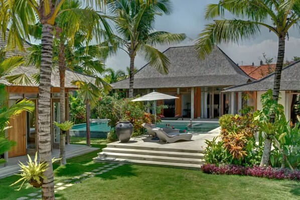 View of the garden, pool and teak joglos from the main living joglo structure.