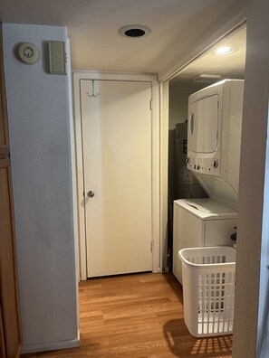 Hallway to Ba which has storage and in-unit laundry
