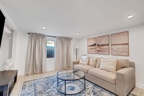 Step into the elegant living room, where comfort and style seamlessly blend. The space is furnished with beautiful, contemporary furniture, offering a chic yet inviting atmosphere perfect for relaxing or entertaining.