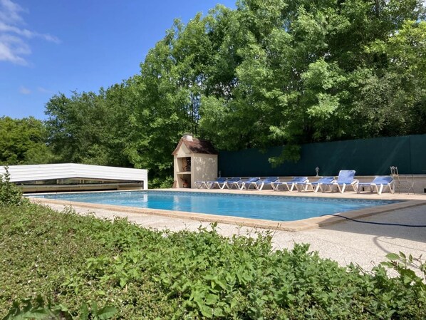 Piscine dans le jardin. Four à pizza.