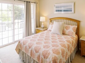 Warm and inviting bedroom featuring a queen bed and access to one of the private decks.