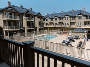Spacious balcony overlooking the community pool—perfect for relaxing on warm summer days.