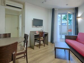 Spacious living area featuring a sofa bed and flat-screen TV, offering a comfortable space to unwind.