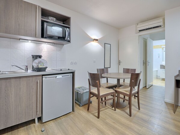 Modern kitchenette with electric hob, microwave, and dining area, perfect for preparing and enjoying meals.