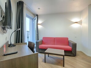 Inviting seating area with a red sofa, perfect for relaxing after exploring nearby Paris and attractions.