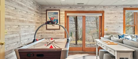 Air hockey and a pool table in the game room.