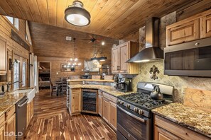 The spacious chef’s kitchen is designed for both functionality and style, featuring a 5-burner gas stove, wine fridge, and an oversized farm sink that makes meal prep effortless. Enjoy stunning lake views as you cook, and gather around the beautiful natural wood bar with seating, perfect for entertaining guests or sharing a casual meal. Fully stocked with every dish, utensil, a...