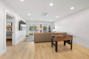 Lower level living room has a foosball table that converts into a pool table or basketball game!