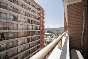 Enjoy a serene view from the balcony, overlooking the vibrant city and lush hills. Perfect for a relaxing getaway!