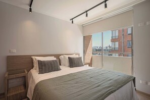 Relax in this cozy bedroom with a stunning balcony view, perfect for unwinding after a day of adventure.