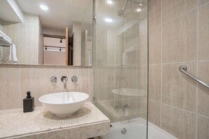 Experience modern comfort in this stylish bathroom, featuring a sleek sink and glass shower for a refreshing retreat.