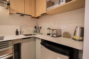 Modern kitchen equipped with stainless steel appliances and sleek cabinetry, perfect for preparing meals during your stay.
