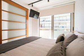 Bright and cozy bedroom with a large bed and modern amenities, perfect for a restful stay.