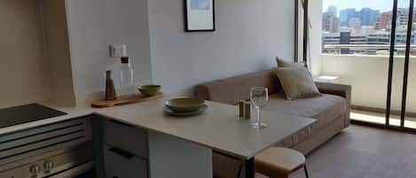 Experience modern comfort in this stylish living area with stunning city views, perfect for relaxation and entertaining during your stay.