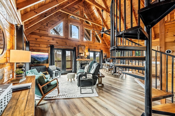 The cabin’s spiral staircase adds a playful architectural touch to the rustic-modern vibe. Head upstairs for more cozy nooks and cabin charm.
