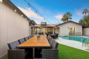 "Gather around the table and indulge in delightful outdoor meals in our spacious backyard."