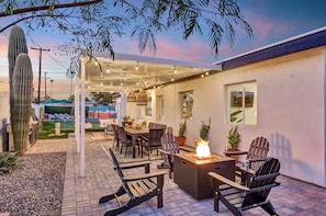 The area is thoughtfully illuminated to enhance the nighttime experience. Ambient lighting, such as soft, warm-toned string lights or strategically placed lanterns, casts a gentle glow over the space.