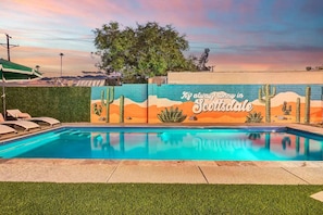 The pool's water is crystal clear. The sunlight dances on the surface, creating gentle ripples that shimmer in varying shades of azure and turquoise. The pool is spacious, with plenty of room for swimming and lounging.