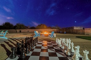 Under the starlit sky, strategy meets serenity. Every move on the oversized chessboard echoes in the quiet night, while the flames dance to the rhythm of thought. A perfect blend of intellect and tranquility.