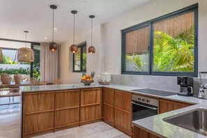 Delicate kitchen with wooden finishes. New appliances and a view of the garden.
