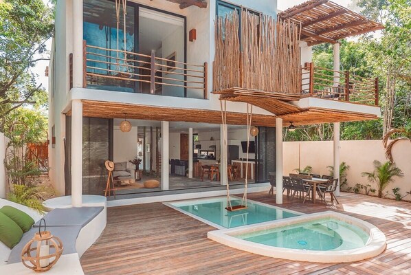 Beautiful rear facade of the house. The unique design pool stands out in the courtyard.
