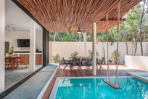 Incredible courtyard with a beautiful pool and outdoor dining area. Large windows connect to the interior.