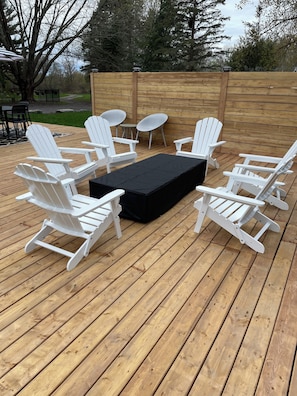 relax in muskoka chairs in front of a modern fire table