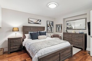 Rest easy on a queen-sized bed with soft, high-quality linens and extra pillows to ensure a good night's sleep. Bedside tables with lamps provide convenient lighting for nighttime reading or unwinding.