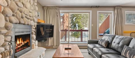 Living room with a (decorative) fireplace, comfortable seating, a TV with Shaw cable & access to the private balcony.