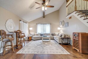 Spacious living area with a large sectional couch, smart TV, and plenty of natural light. Ideal for relaxing, entertaining, or enjoying board games with the family