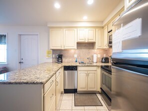 Fully equipped modern kitchen featuring stainless steel appliances and ample counter space.