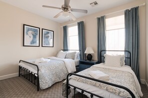 Guest bedroom has queen and twin beds. Closet includes luggage rack and dresser.