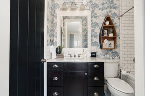Guest bathroom in hallway also connects to guest bedroom with a pocket door. 