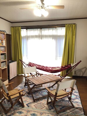 The living room is equipped with a hammock and a table.