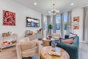 Step into a chic oasis inspired by Music City! This stylish living area, featuring contemporary decor with a fun Dolly Parton touch, is perfect for gatherings and planning your Nashville adventures. Enjoy luxury and create unforgettable memories in this elegant vacation rental.
