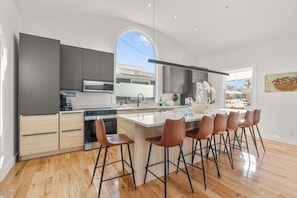 The open floor plan seamlessly connects the kitchen to the living and dining areas, making it the heart of the home for socializing and entertaining.