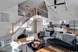 View of living room, with kitchen and loft