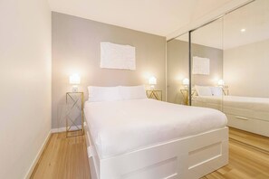 Drift into relaxation on the plush queen bed, complemented by warm lighting and ample built-in wardrobe space.