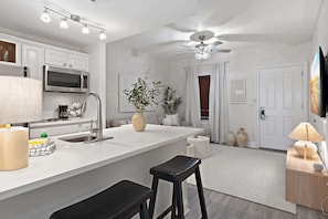 Kitchen: Bar seating, stovetop, microwave, refrigerator, drip coffee maker, cookware & dinnerware