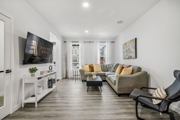 Main floor living room with a 65" smart TV and cozy seating options.