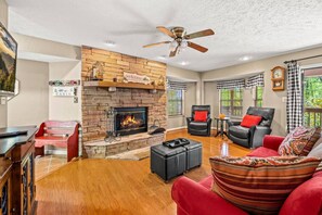 Relax in the cozy living room with a seasonal wood-burning fireplace and peaceful mountain views.