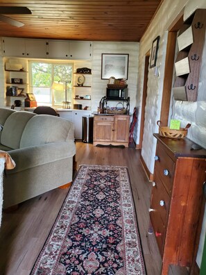 Entering guesthouse via front door, walking into living room, sofa bed couch