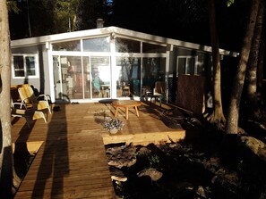 Cozy Cottage Exterior & Spacious Deck – A classic lakefront retreat with a large deck, perfect for outdoor dining, relaxing with a morning coffee, or enjoying a sunset by the firepit. Nestled among the trees for privacy and tranquility.
