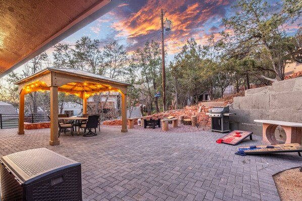 A cozy gazebo in the backyard, nestled amidst lush greenery, providing a tranquil space for outdoor relaxation.