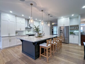 Chef's kitchen with a large kitchen island and partially stocked pantry.