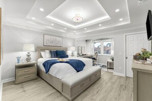 Primary bedroom with a comfortable king-size-bed, inviting decor, flat screen TV, a workspace, pool view and ensuite bathroom