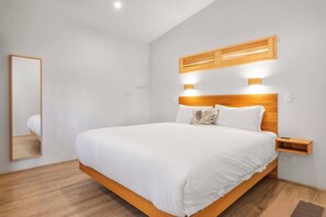 The bedroom is a cosy retreat set with a king bed and sliding doors for privacy.